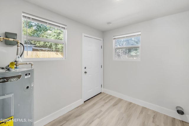 interior space featuring light hardwood / wood-style floors, a wealth of natural light, and water heater