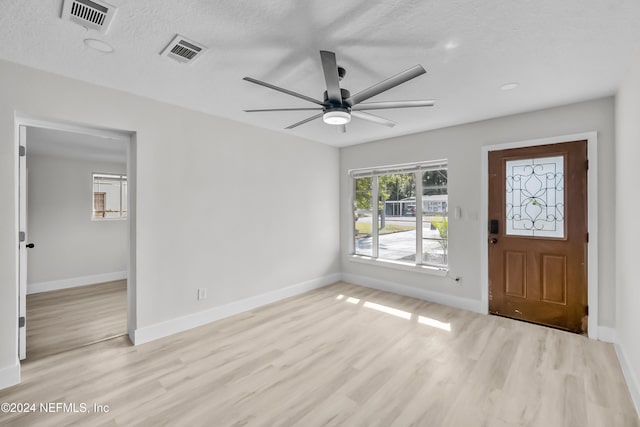 entryway featuring ceiling fan, light hardwood / wood-style flooring, and a textured ceiling