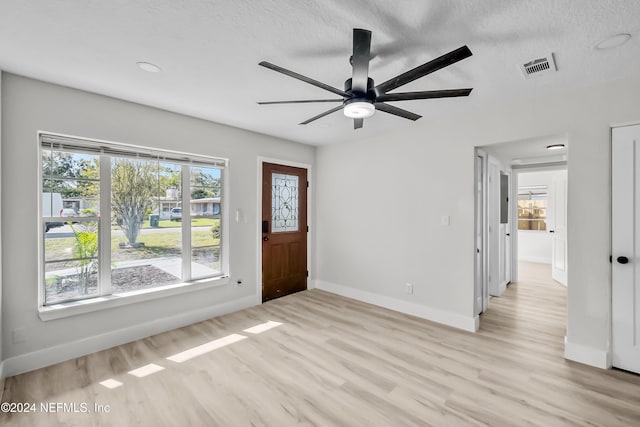 foyer featuring a textured ceiling, light hardwood / wood-style flooring, and ceiling fan