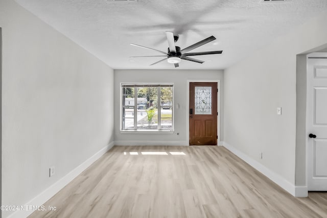 interior space featuring ceiling fan, light hardwood / wood-style floors, and a textured ceiling