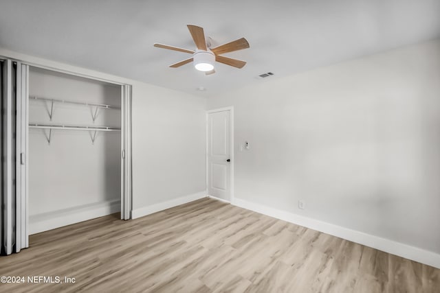 unfurnished bedroom with a closet, light hardwood / wood-style floors, and ceiling fan