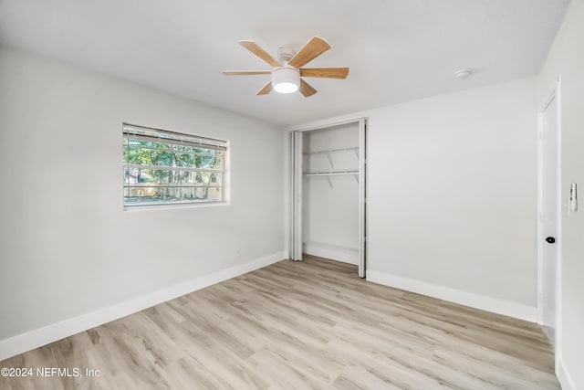 unfurnished bedroom with a closet, light hardwood / wood-style floors, and ceiling fan