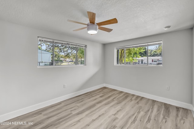 unfurnished room featuring ceiling fan, light wood-type flooring, and a textured ceiling