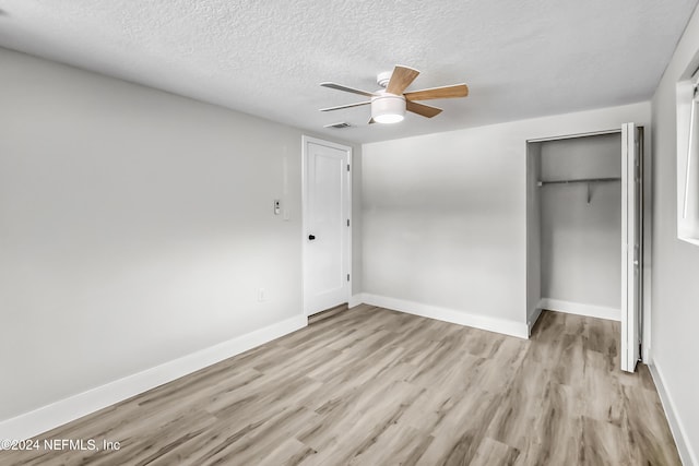 unfurnished bedroom with a textured ceiling, light hardwood / wood-style floors, and ceiling fan