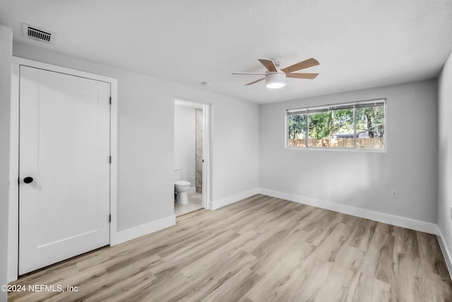 unfurnished bedroom with a closet, connected bathroom, light hardwood / wood-style floors, and ceiling fan