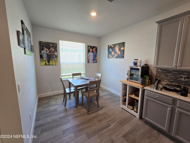 dining space with dark hardwood / wood-style flooring and a textured ceiling