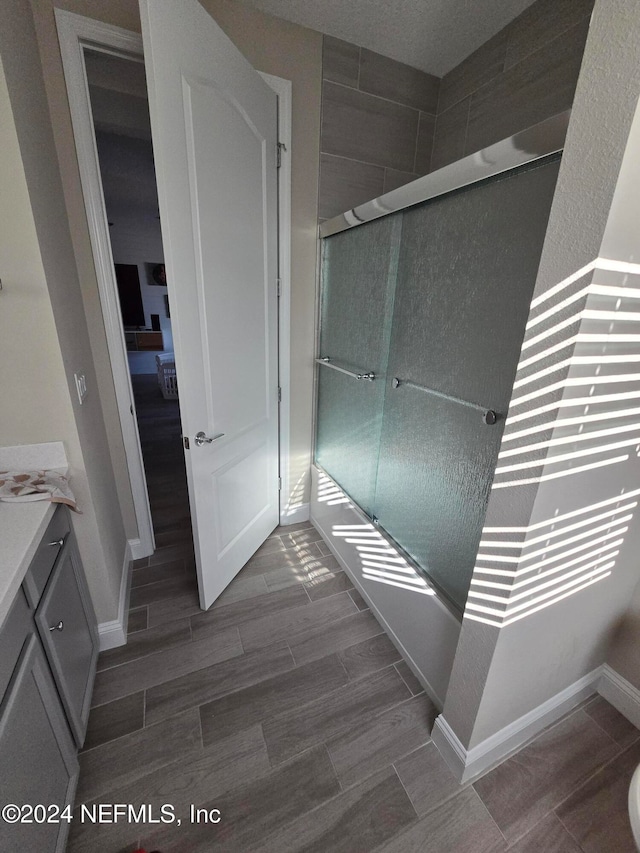 bathroom with vanity, an enclosed shower, and hardwood / wood-style flooring