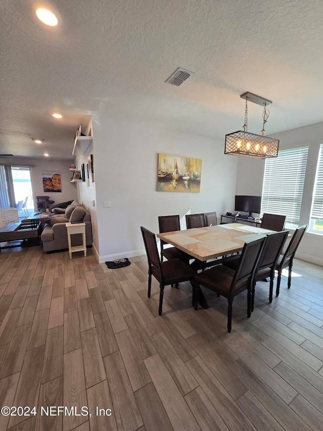 dining space featuring hardwood / wood-style floors and a textured ceiling