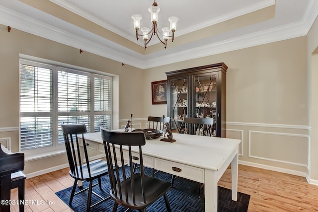 dining space featuring wood-type flooring, an inviting chandelier, and ornamental molding