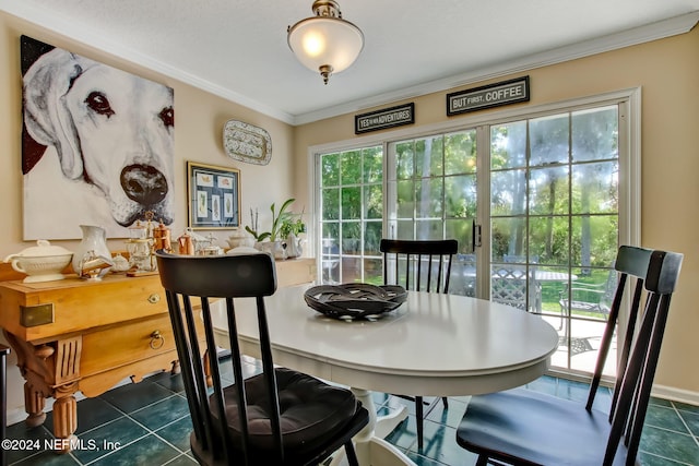 dining area with crown molding and dark tile patterned floors