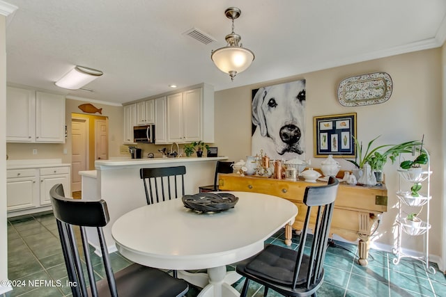 tiled dining area featuring ornamental molding