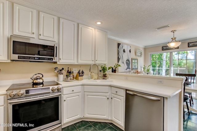 kitchen with sink, hanging light fixtures, kitchen peninsula, white cabinets, and appliances with stainless steel finishes