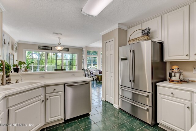 kitchen with white cabinetry, stainless steel appliances, crown molding, decorative light fixtures, and dark tile patterned flooring