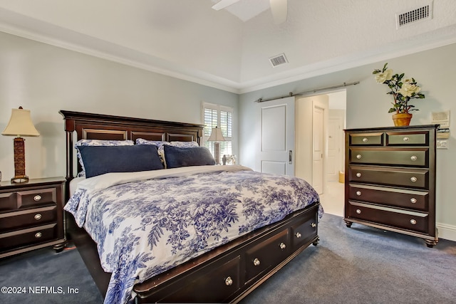 carpeted bedroom featuring ceiling fan, a barn door, and ornamental molding