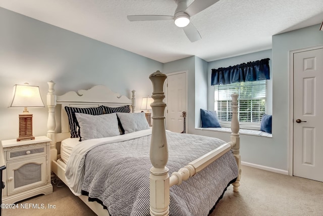 carpeted bedroom featuring ceiling fan and a textured ceiling