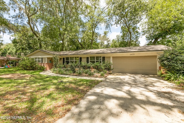 ranch-style house with a garage and a front lawn