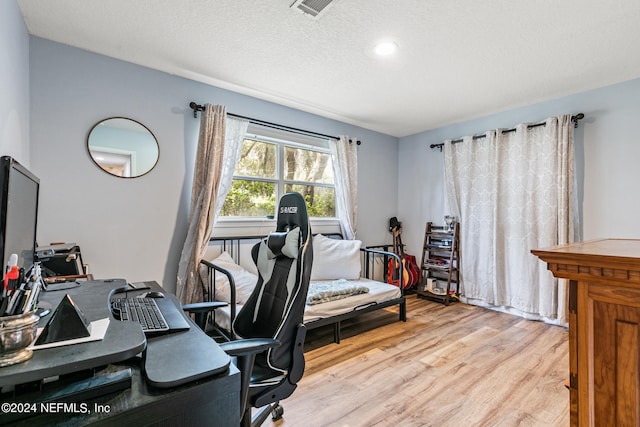 office with a textured ceiling and light hardwood / wood-style flooring