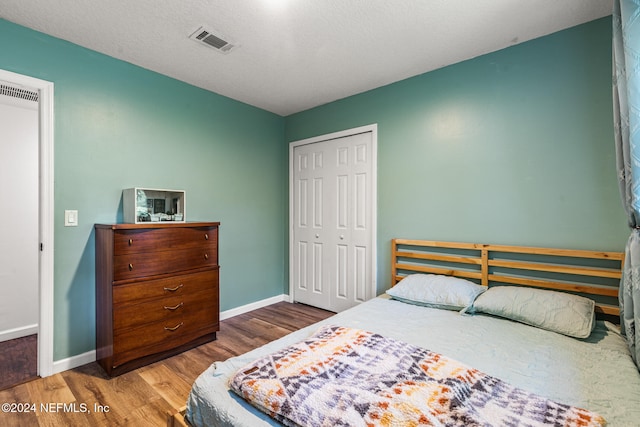 bedroom featuring a textured ceiling, hardwood / wood-style flooring, and a closet