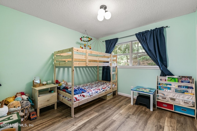 bedroom with hardwood / wood-style floors and a textured ceiling