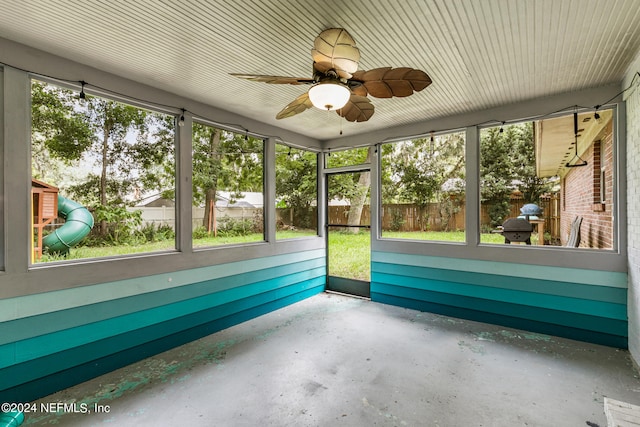 unfurnished sunroom with ceiling fan