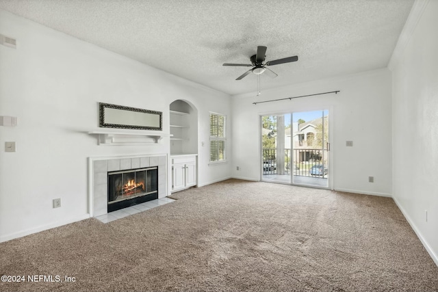 unfurnished living room with a tile fireplace, light carpet, built in features, and ceiling fan