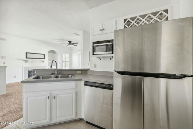 kitchen with white cabinets, appliances with stainless steel finishes, ceiling fan, and sink