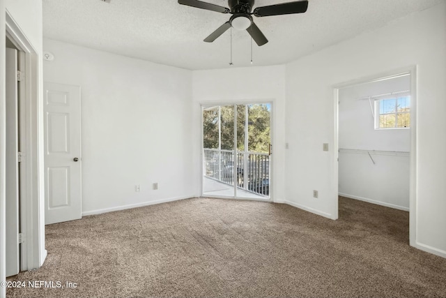 unfurnished bedroom with access to exterior, carpet floors, multiple windows, and ceiling fan