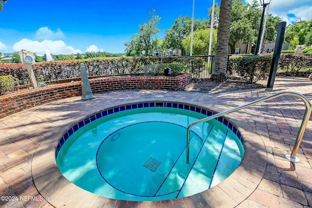 view of swimming pool with a hot tub