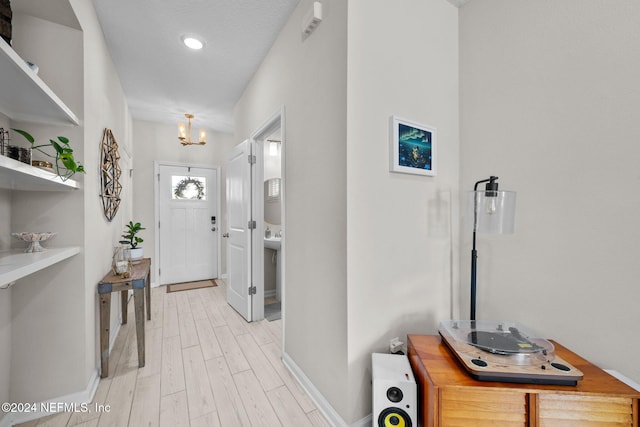 foyer entrance with light wood-type flooring and a textured ceiling