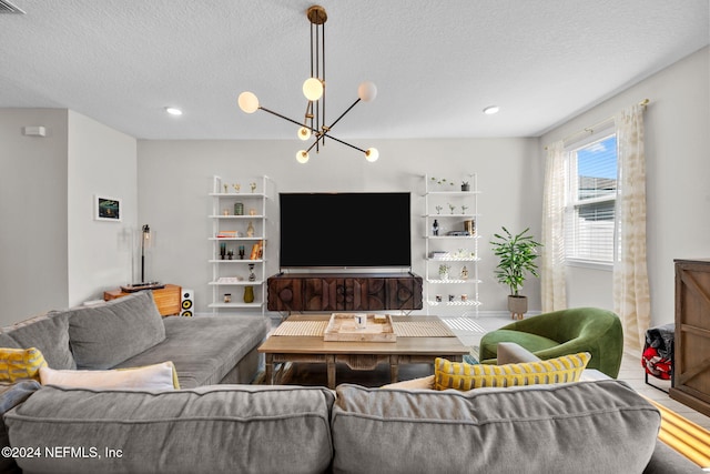 living room featuring a textured ceiling and an inviting chandelier