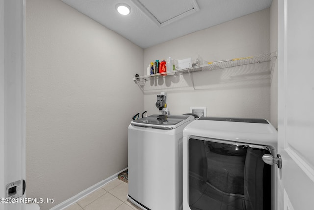 washroom featuring washer and clothes dryer and light tile patterned floors