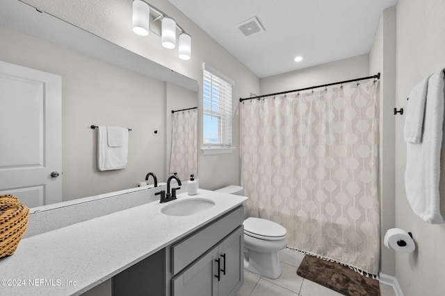 bathroom featuring tile patterned floors, walk in shower, vanity, and toilet