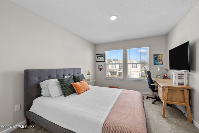 bedroom with carpet and a textured ceiling