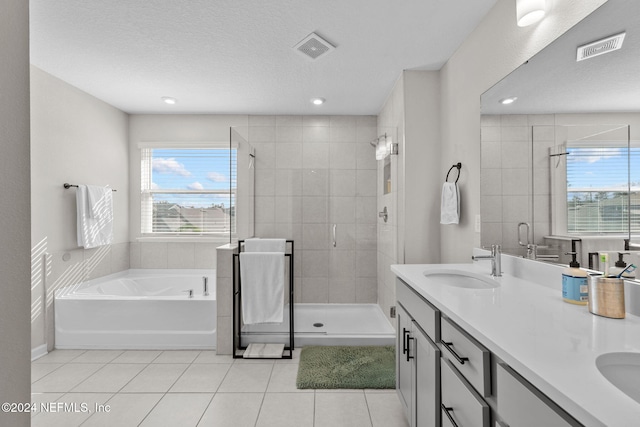 bathroom with tile patterned flooring, vanity, a textured ceiling, and independent shower and bath