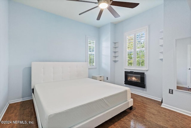 bedroom with dark hardwood / wood-style flooring and ceiling fan