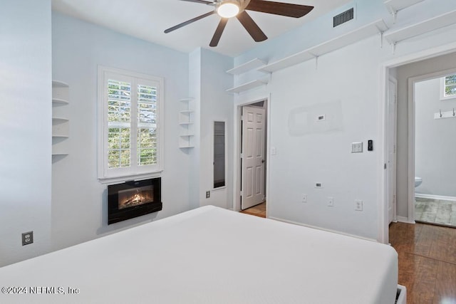 bedroom featuring ensuite bath, ceiling fan, and hardwood / wood-style flooring