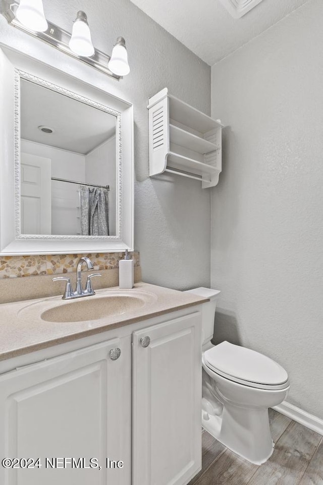 bathroom with hardwood / wood-style flooring, vanity, toilet, and a shower with shower curtain