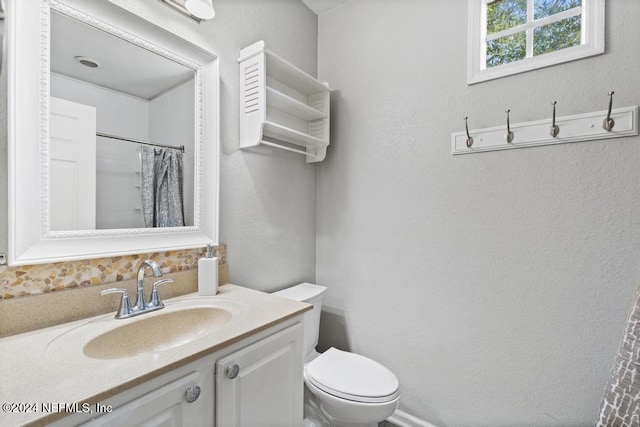 bathroom featuring vanity, toilet, and walk in shower