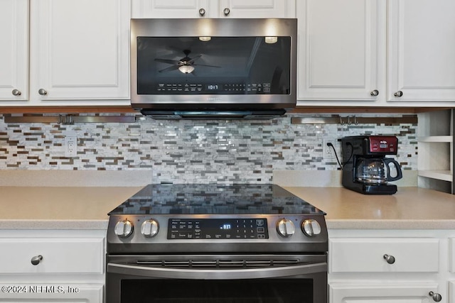 kitchen featuring decorative backsplash, stainless steel appliances, and white cabinets