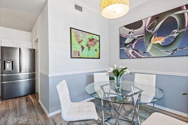 dining room featuring hardwood / wood-style flooring and crown molding