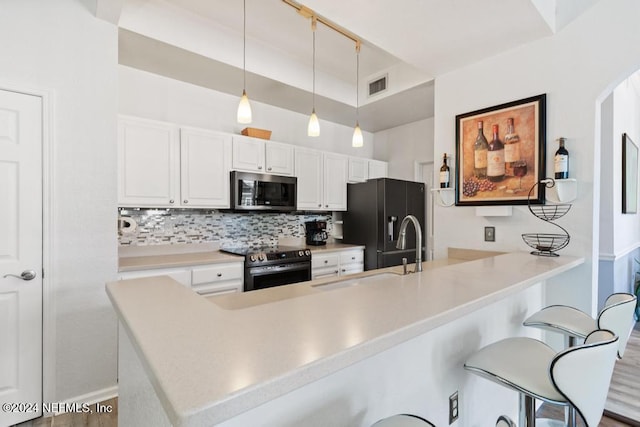 kitchen featuring pendant lighting, a breakfast bar area, decorative backsplash, white cabinetry, and stainless steel appliances