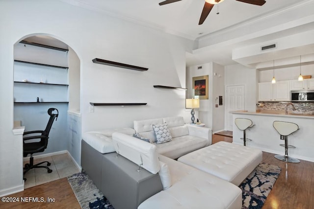 living room with ceiling fan, sink, dark hardwood / wood-style floors, and ornamental molding