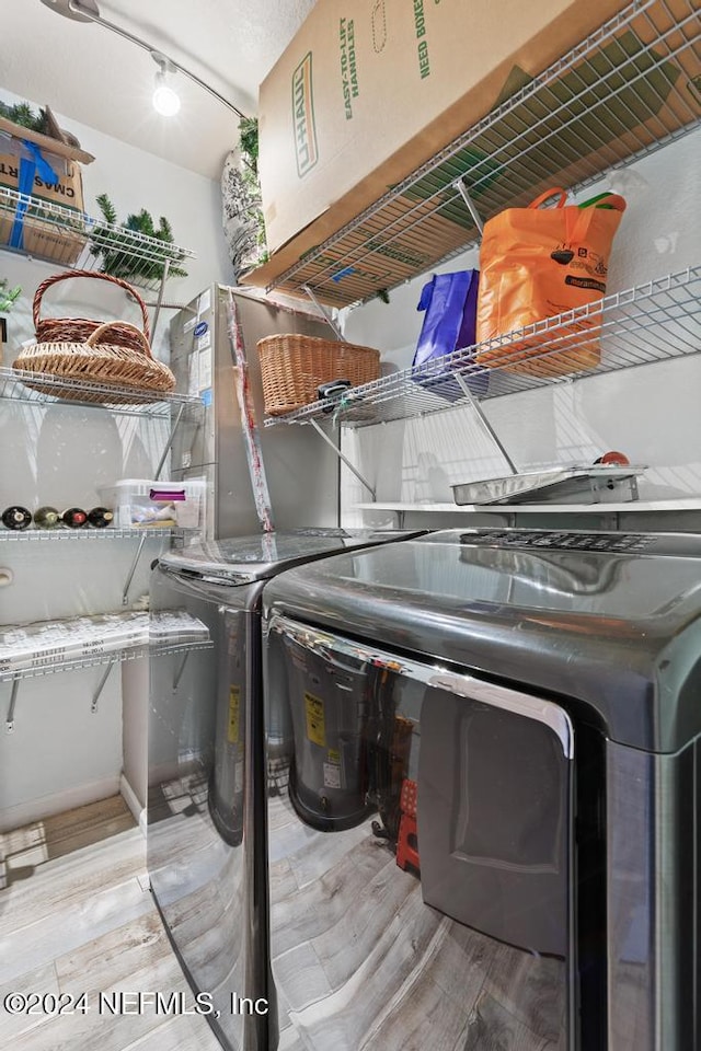 washroom featuring washing machine and clothes dryer and light hardwood / wood-style floors