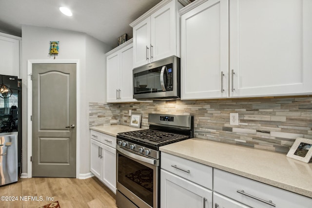 kitchen featuring white cabinets, appliances with stainless steel finishes, light hardwood / wood-style floors, and tasteful backsplash