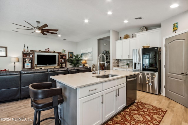 kitchen featuring sink, white cabinetry, an island with sink, and appliances with stainless steel finishes