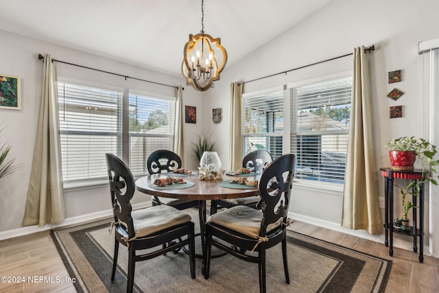 dining space featuring lofted ceiling, light wood-type flooring, and an inviting chandelier