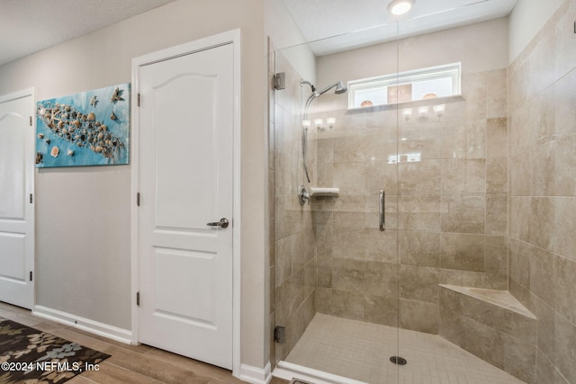 bathroom featuring hardwood / wood-style flooring and a shower with shower door