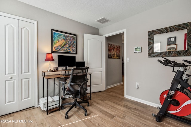 office space with light hardwood / wood-style floors and a textured ceiling