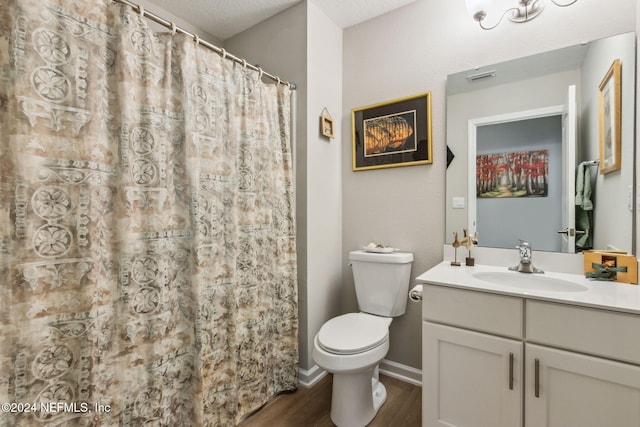 bathroom with hardwood / wood-style floors, vanity, toilet, a textured ceiling, and curtained shower