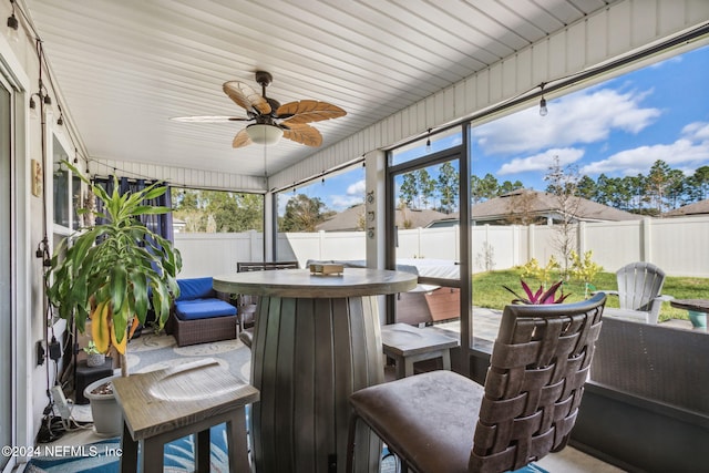 sunroom / solarium featuring ceiling fan